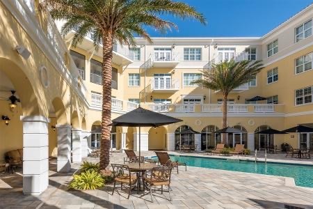 Exterior image of The Summit of Citrus Hills courtyard and pool with shaded seating.